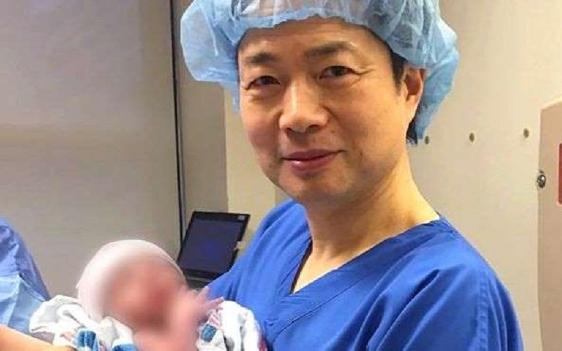  O médico John Zhang com o bebê nascido com a técnica, usada para evitar que ele adquirisse síndrome 